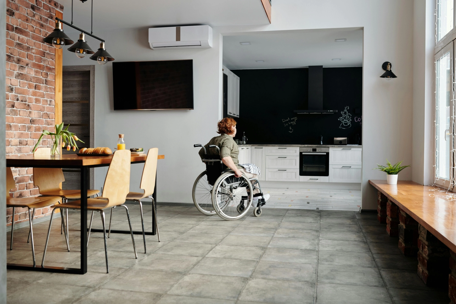 Linas - Alltagsbegleitung - eine Person im Rollstuhl in einer modernen, offenen Wohnung
